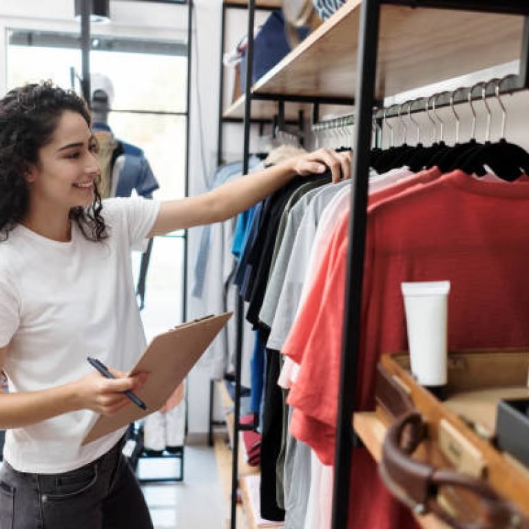Latin woman working small clothing store.
